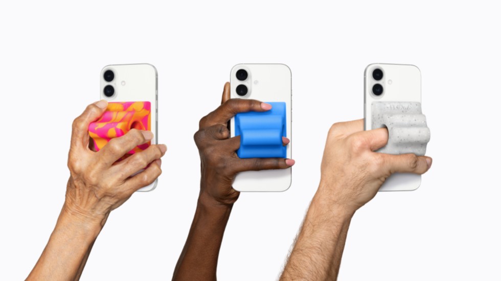 Três mãos seguram aparelhos iPhone 17 Pro, cada um equipado com um acessório adaptativo Grip & Stand colorido da Hikawa.