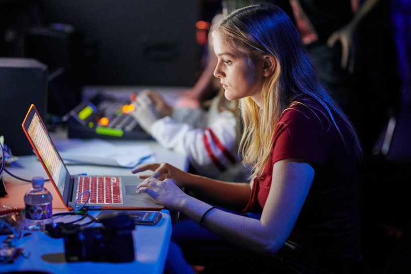 Un élève producteur qui utilise un ordinateur en coulisses.