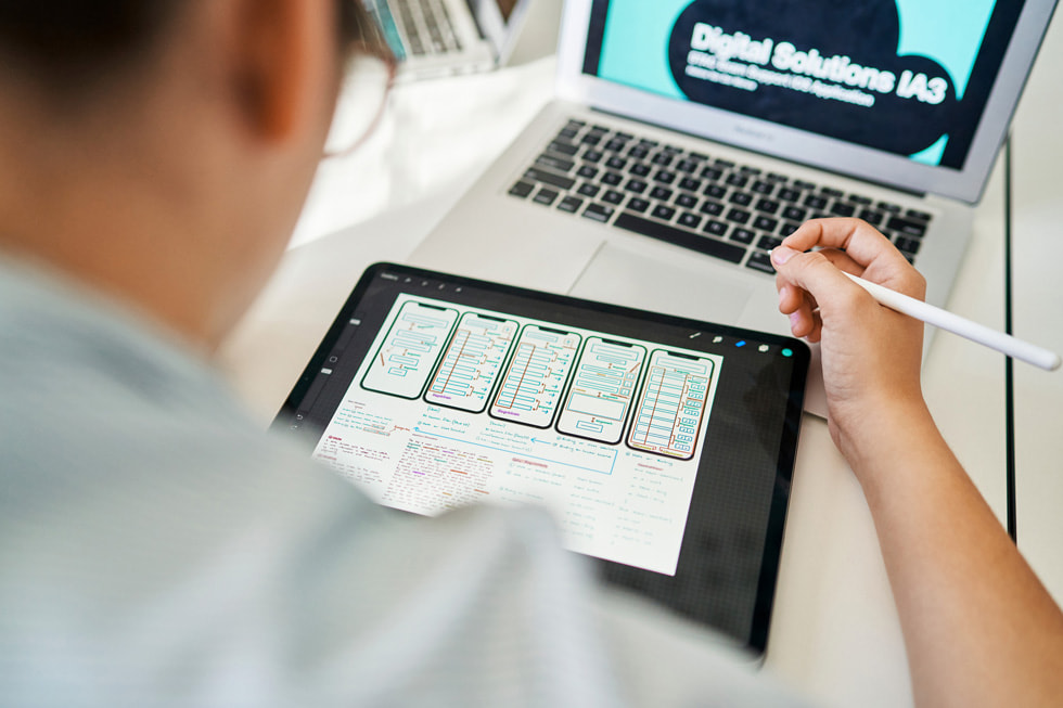 Élève développant une app à l’aide d’un Apple Pencil, d’iPad, et de MacBook Air.