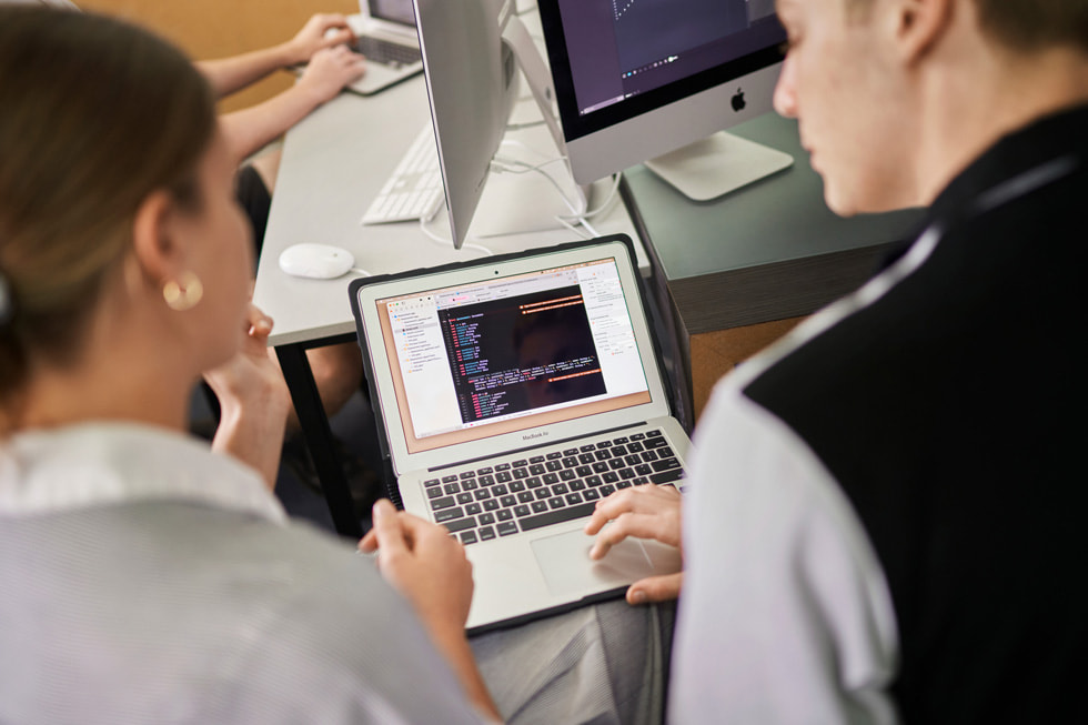 Une élève et un professeur du Siena Catholic College passant du code en revue sur MacBook Air.