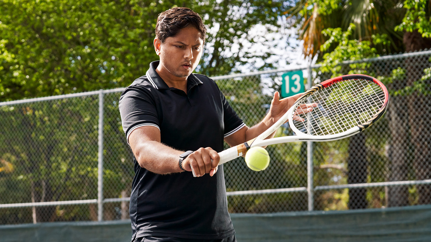 Sahai slår et baghåndsslag på en tennisbane.