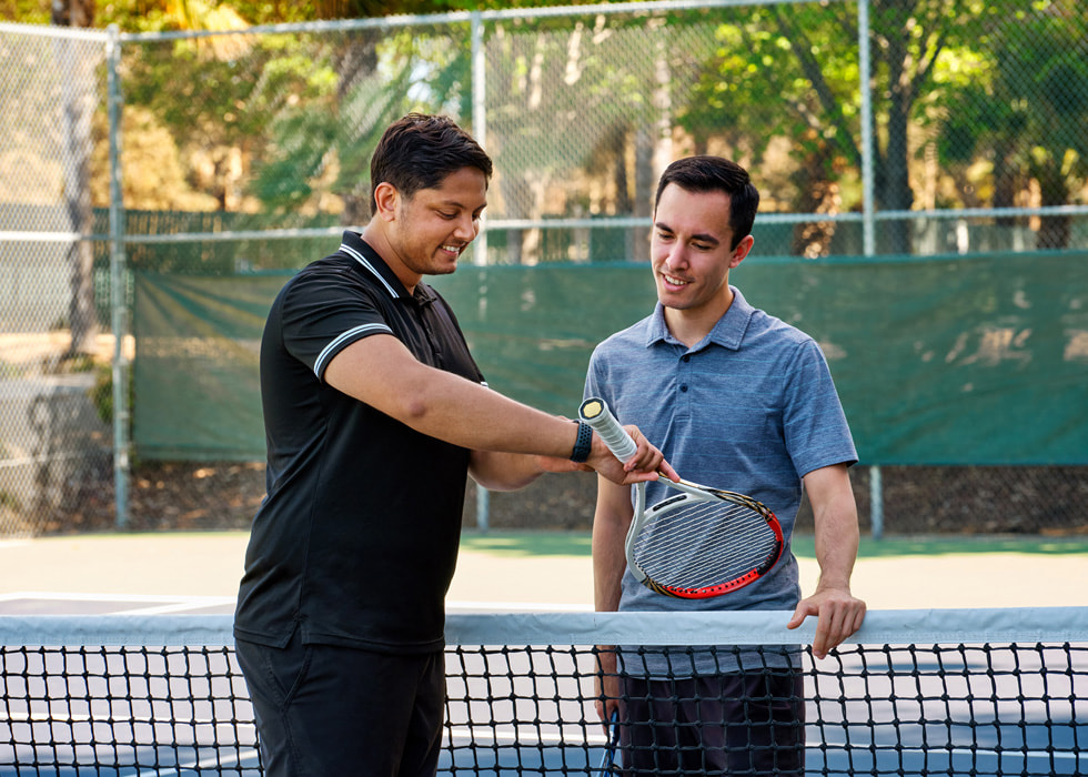 Sahai viser en tennisspiller sit Apple Watch ude på tennisbanen.