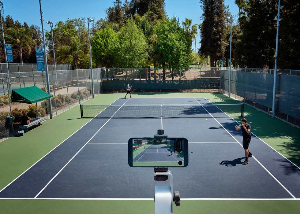 En iPhone er placeret, så den kan optage to tennisspillere på banen.