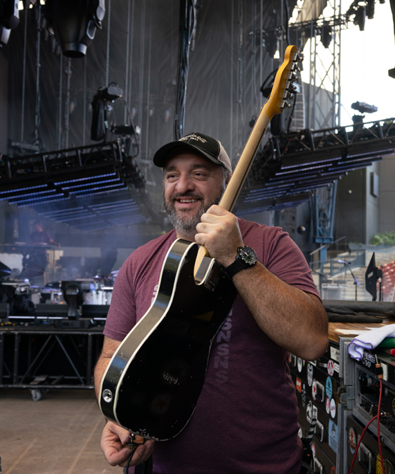 Le technicien Carlos Gutierrez tient une guitare en arrière-scène. 