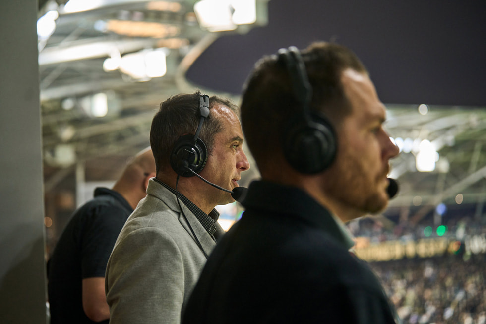 Programværterne Max Bretos og Brian Dunseth ses med headsets på bag kulisserne til en LAFC-kamp.