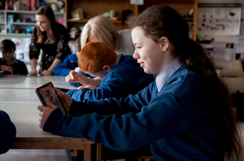 Une fille utilise iPad en classe. 