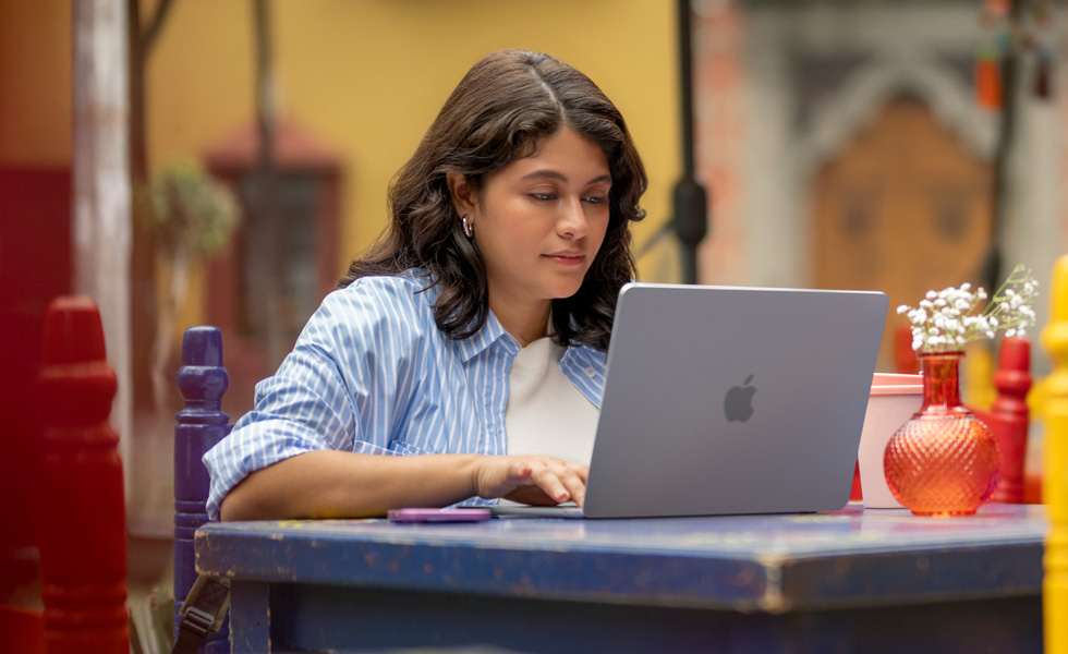 一名學生在 MacBook 上打字。